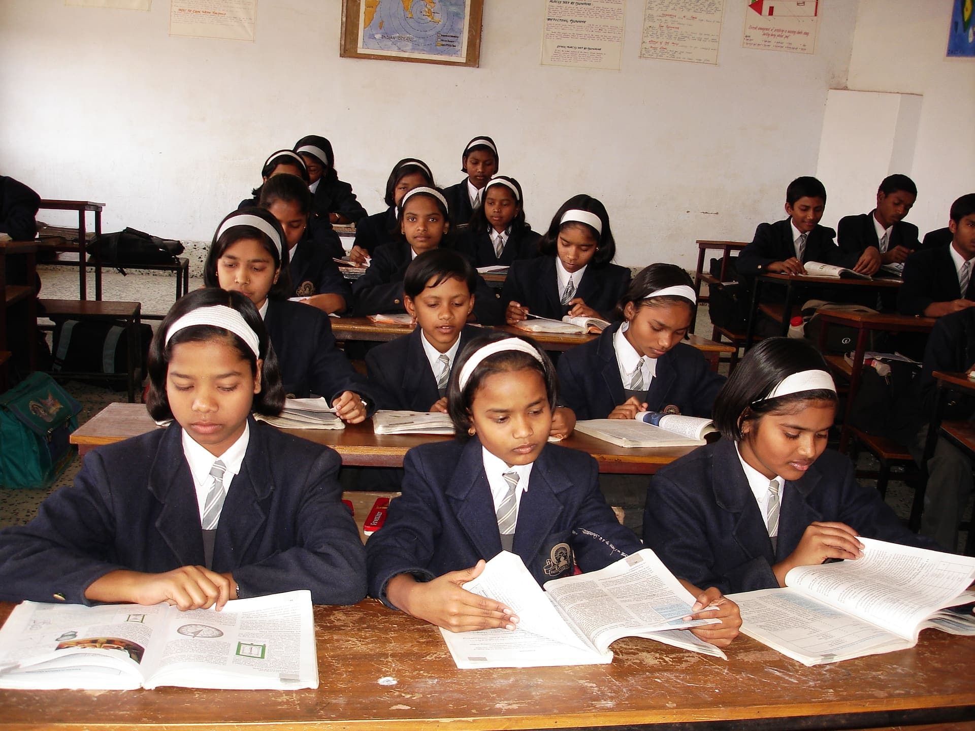 A class of girls in school uniform reading at their desks