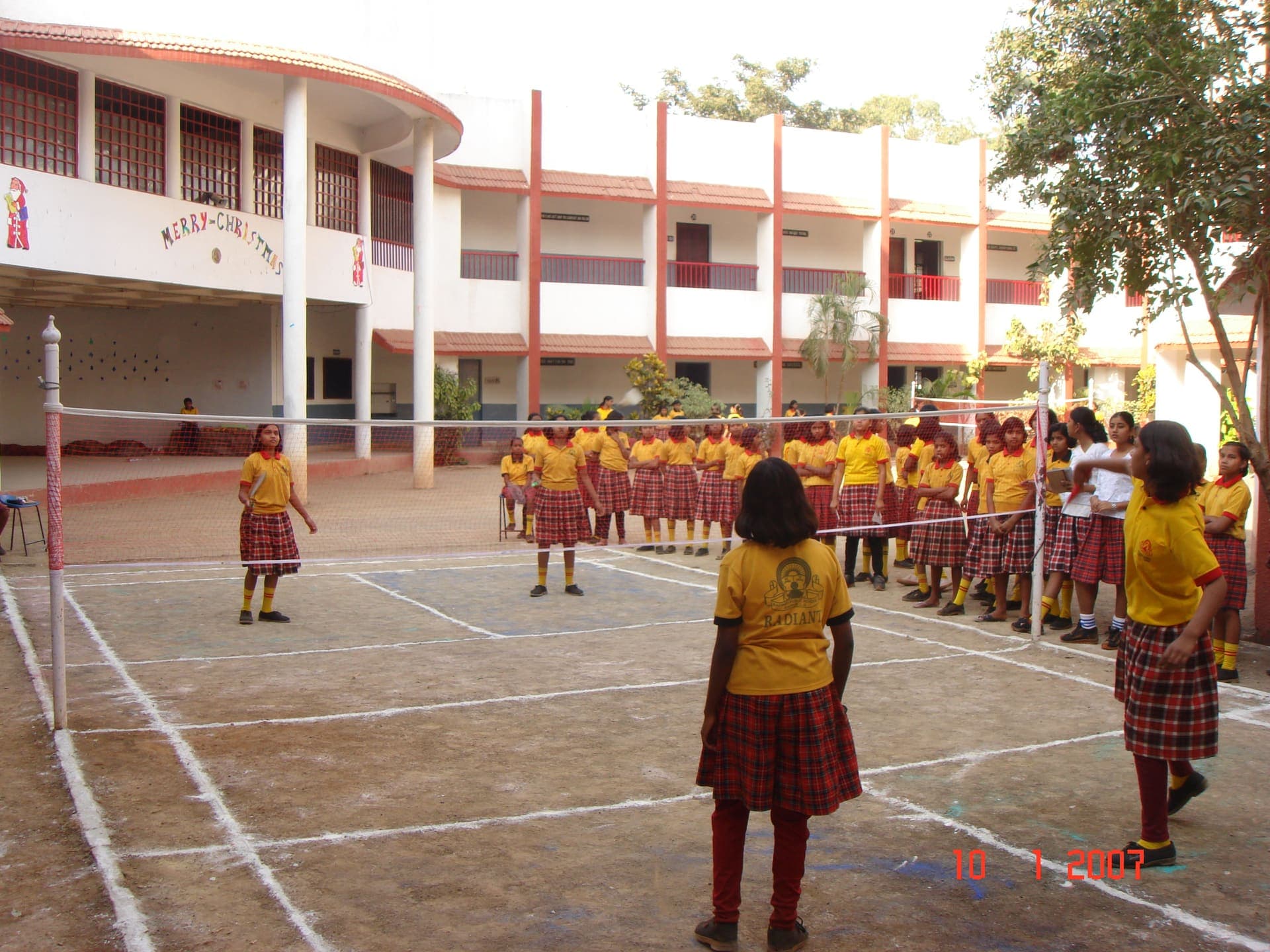 Girls playing volleyball in the school courtyard