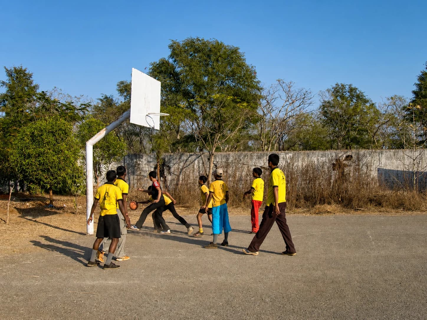 Boys playing basketball on the school grounds