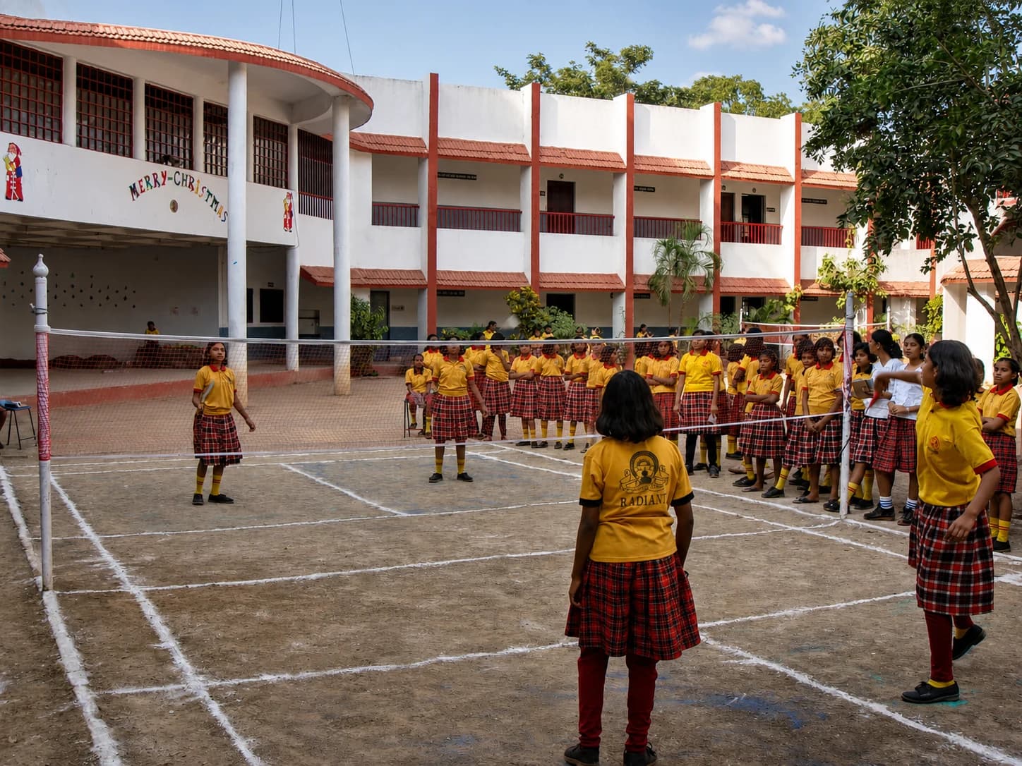 Girls playing volleyball in the school courtyard